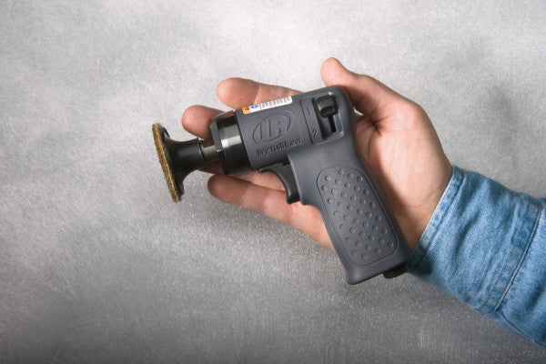 Meuleuse pneumatique 3103XPA Ingersoll Rand, mini-meuleuse nue, ici avec un disque abrasif adapté, dans la main d'un homme - à titre de comparaison de taille